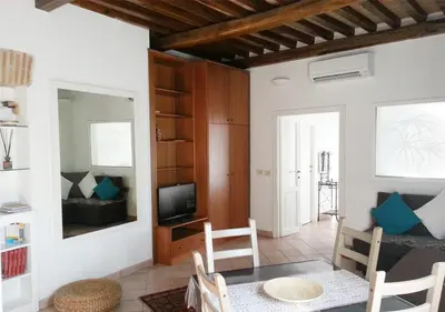 a living room with a table and a tv at Panoramic Apartment in Rome