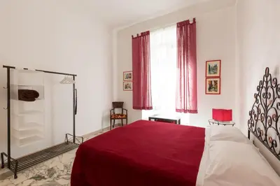 a bedroom with a red bed and a window at Simon's place in Rome