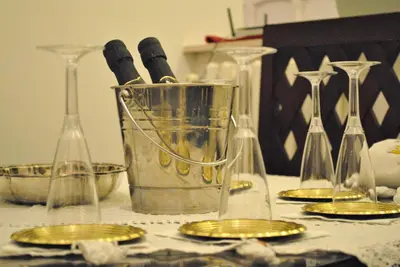 a table with a bucket of wine bottles and gold chargers at Simon's place in Rome