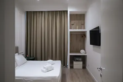 a hotel room with two beds and a television at Aureliana Luxury Apartments in Rome