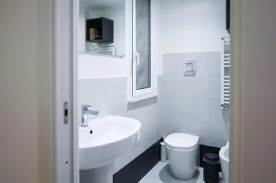a white bathroom with a sink and a toilet at Aureliana Luxury Apartments in Rome