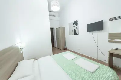a bedroom with a bed with a television and a desk at Lemei House in Rome