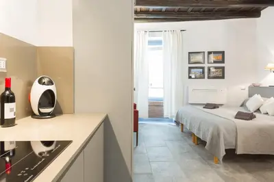 a bedroom with a bed and a kitchen with a sink at Roman Forum Suite in Rome