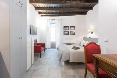 a bedroom with a bed and two red chairs at Roman Forum Suite in Rome