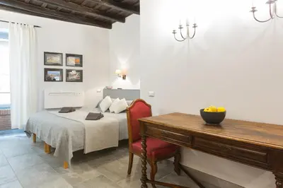 a bedroom with a bed and a table and a desk at Roman Forum Suite in Rome