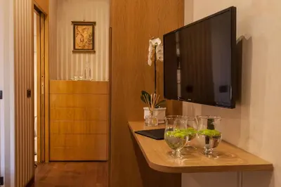 a television on a wall with glasses on a table at Prestigious Apartment Piazza Navona in Rome