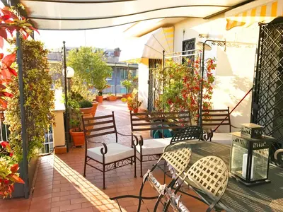 a patio with chairs and a table on a balcony at Roma Suite Balduina in Rome