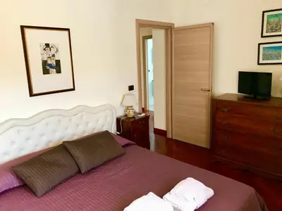 a bedroom with a bed and a dresser and a television at Roma Suite Balduina in Rome