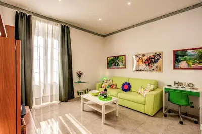 a living room with a green couch and a table at GreenSugarHome in Rome