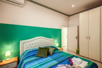 a bedroom with a green accent wall and a bed at GreenSugarHome in Rome