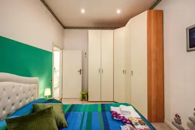 a bedroom with a bed and a green wall at GreenSugarHome in Rome