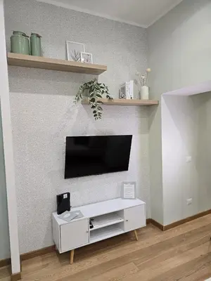 a living room with a tv and a white cabinet at Rome Candia Holiday House in Rome