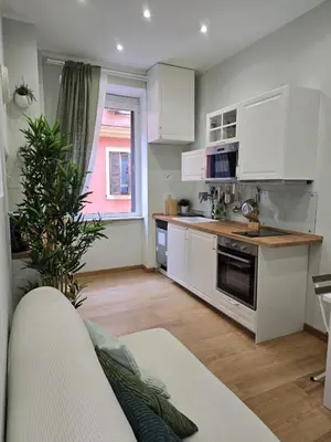 a kitchen with white cabinets and a counter top at Rome Candia Holiday House in Rome