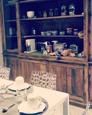 a dining room with a table and a shelf with dishes at Tuttelestrade - The apartment in Rome