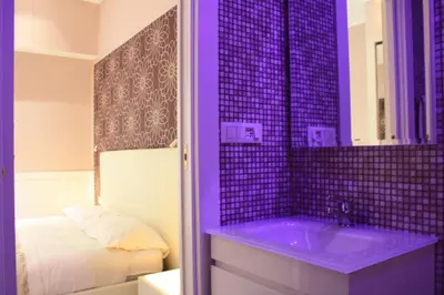 a bathroom with a purple sink and a bed at Tuttelestrade - The apartment in Rome