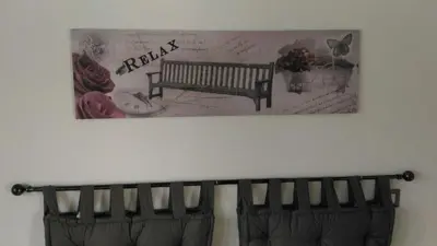 a picture of a bench on a wall with roses at La casa per te in Rome