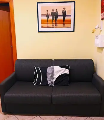 a black couch with two pillows in a room at TOM'S HOUSE in Rome