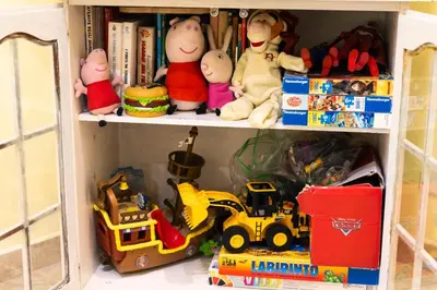 a toy cabinet filled with toys and books at TOM'S HOUSE in Rome