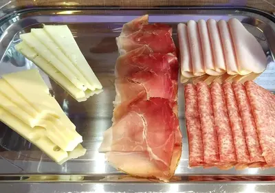 a tray with cheese and meats and other food items at J24 B&B in Rome