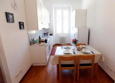 a kitchen with a table and chairs and a kitchen with white cabinets at Big House Colosseum in Rome