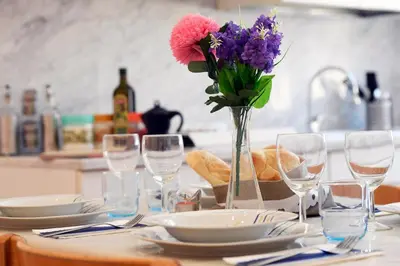 a table with glasses and a vase of flowers on it at Big House Colosseum in Rome