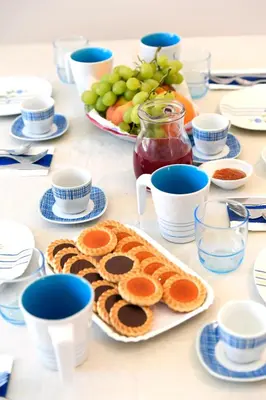 a table with blue and white cups and plates of food at Big House Colosseum in Rome