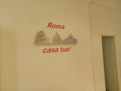 a sign on a wall that reads roma casa tula at Big House Colosseum in Rome