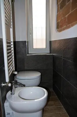 a bathroom with a white toilet and a window at La Casa di Marti in Rome