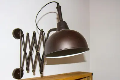 a black lamp hanging from a wall with some utensils at La Casa di Marti in Rome