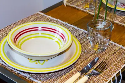 a bowl and a plate on a table with a glass at La Casa di Marti in Rome