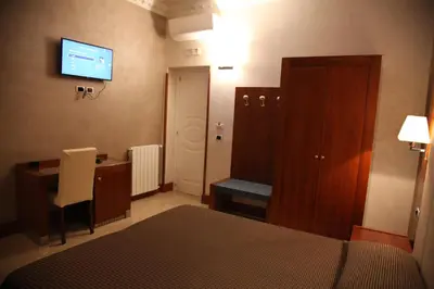 a bedroom with a bed and a desk and a television at B&B Federica's House In Rome in Rome