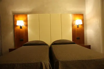 two beds in a room with lights on the wall at B&B Federica's House In Rome in Rome