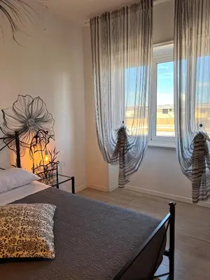 a bedroom with a bed and a large window at Eufonia Vinyl Friendly Apartment in Rome
