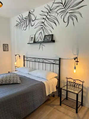 a bedroom with a bed with a plant mural on the wall at Eufonia Vinyl Friendly Apartment in Rome