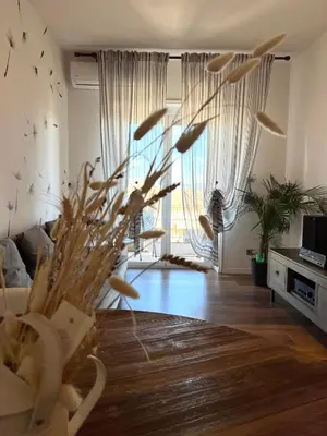 a living room with a vase filled with feathers at Eufonia Vinyl Friendly Apartment in Rome