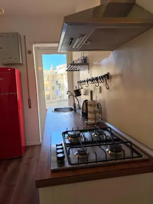 a kitchen with a stove top oven next to a window at Eufonia Vinyl Friendly Apartment in Rome