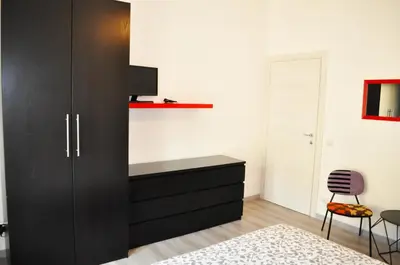 a bedroom with a black cabinet and a chair at 