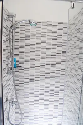 a shower in a bathroom with a tile wall at 