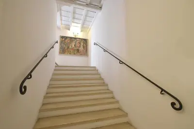 a staircase in a building with a painting on the wall at LM Suites Spagna in Rome