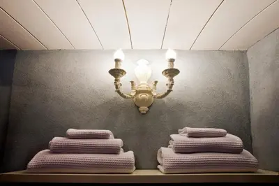 a chandelier and three folded towels on a shelf at LM Suites Spagna in Rome