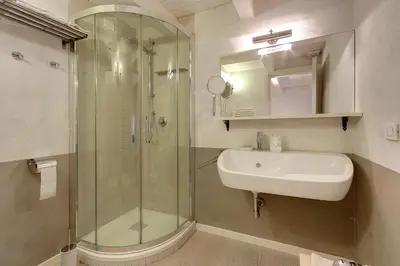 a bathroom with a glass shower and a sink at LM Suites Spagna in Rome