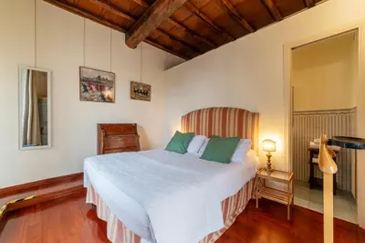 a bedroom with a large white bed with green pillows at Clock Terrace House in Rome