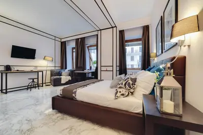 a bedroom with a large bed and a living room at Repubblica Central Suite in Rome
