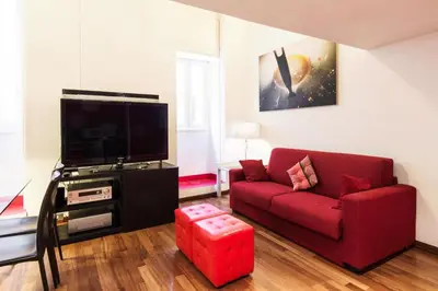 a living room with a red couch and a tv at RSH Balestrari Apartments in Rome