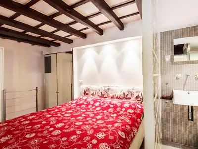 a bedroom with a red bed and a sink at RSH Balestrari Apartments in Rome