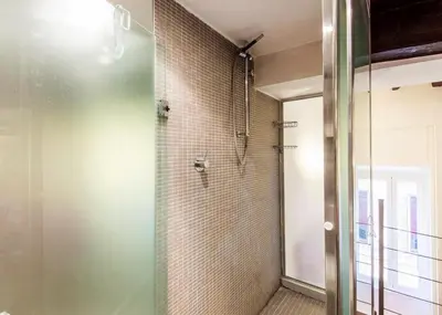 a bathroom with a shower with a glass door at RSH Balestrari Apartments in Rome