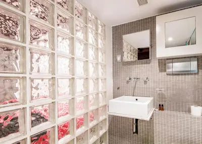 a bathroom with a sink and a tile wall at RSH Balestrari Apartments in Rome