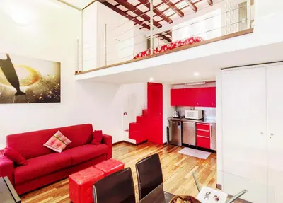a living room with a red couch and a kitchen at RSH Balestrari Apartments in Rome