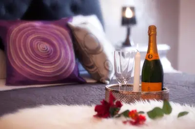a bottle of champagne and a glass on a bed at Luxury Domus Amadeus in Rome