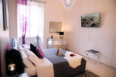 a bedroom with a bed and a chandelier at Luxury Domus Amadeus in Rome